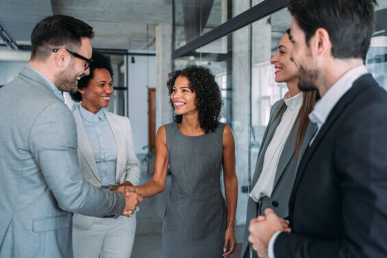 Business people shaking hands in the office. Business persons handshaking during a meeting in modern office.